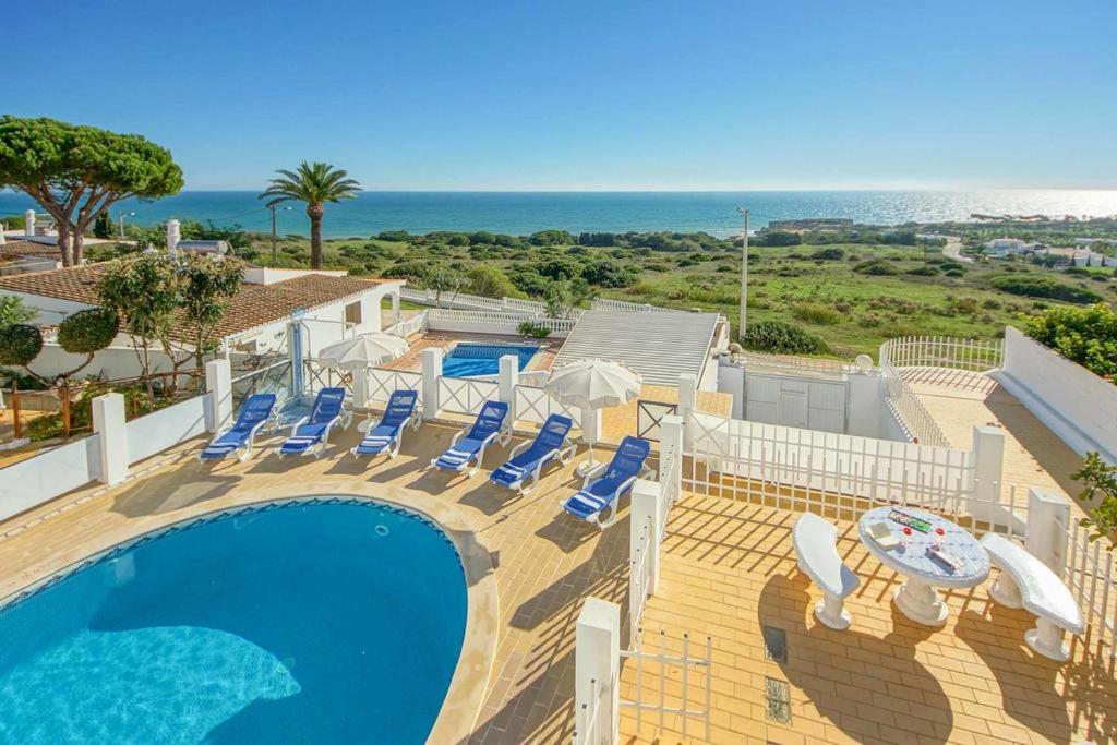 a swimming pool with lounge chairs and the ocean at Villa Albuar in Patroves
