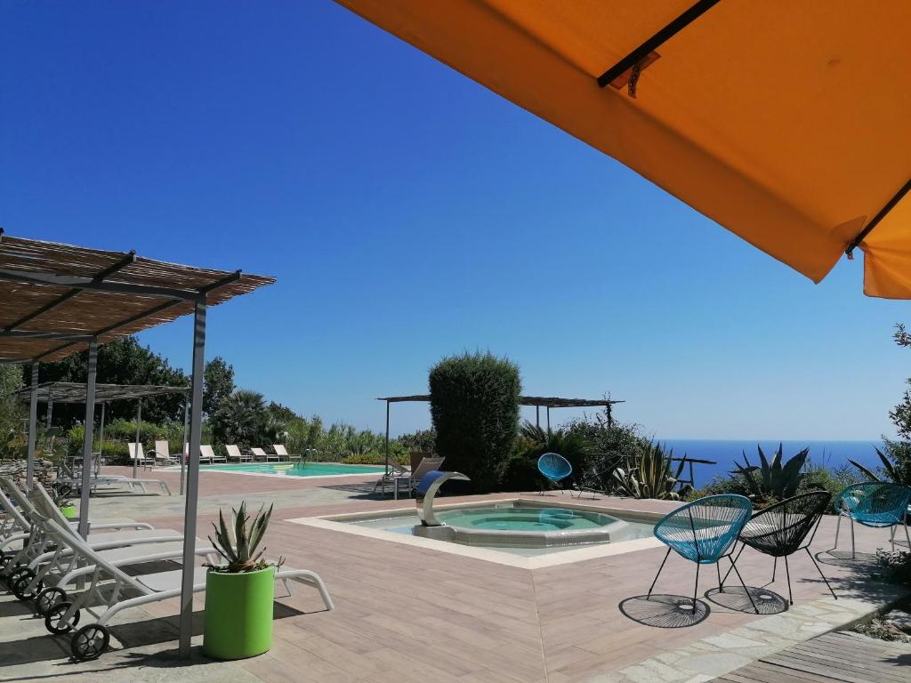 a swimming pool with chairs and an umbrella at Oroverde in Bergeggi