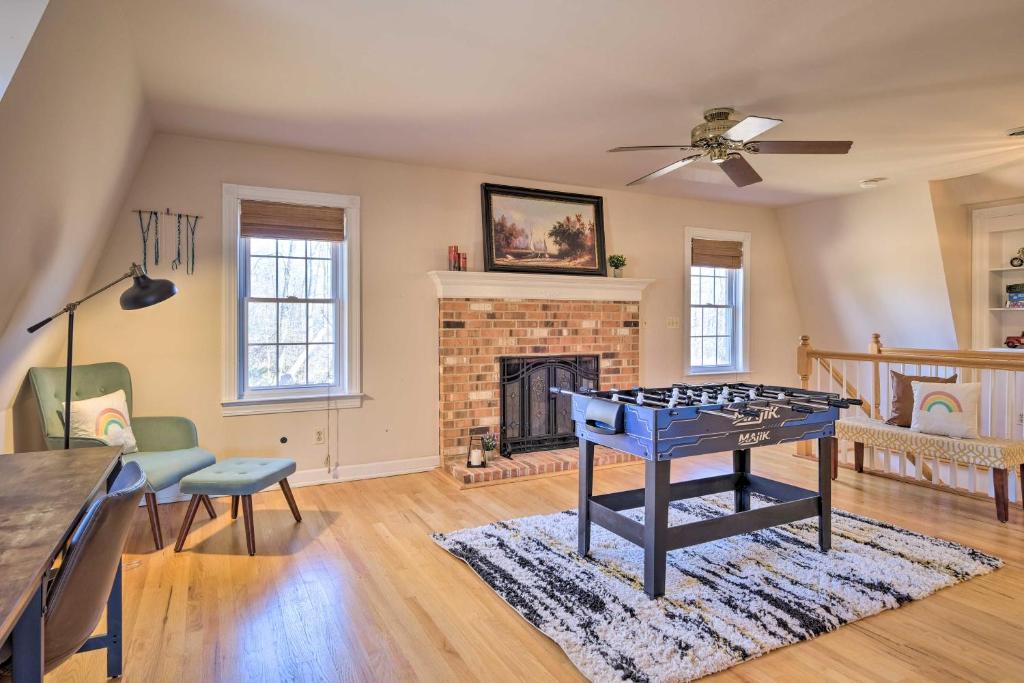 a living room with a ping pong table in front of a fireplace at Pet-Friendly Cottage with Game Room and Fire Pit! in Syria