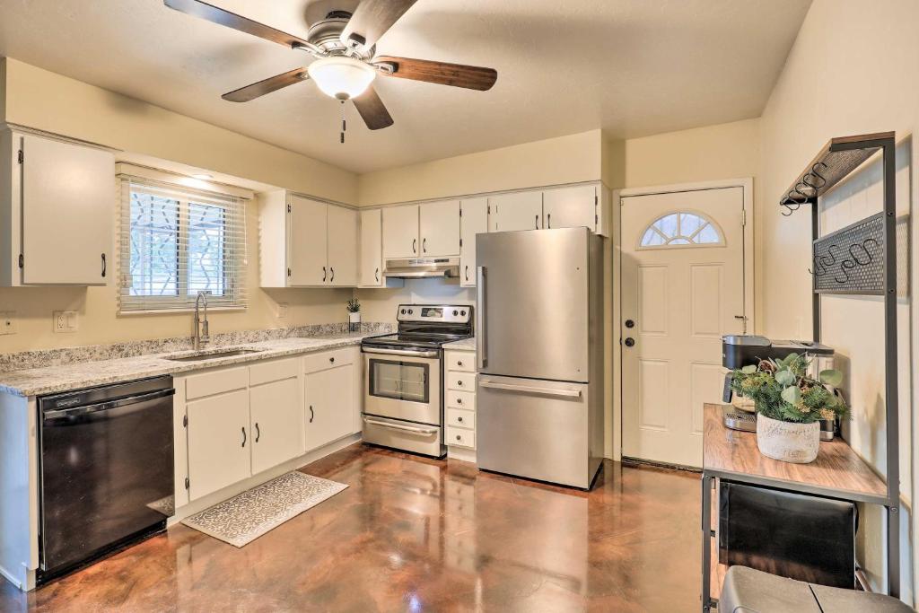 a kitchen with white cabinets and a stainless steel refrigerator at Sunny Tucson Abode with Fire Pit 9 Mi to U of A in Tucson