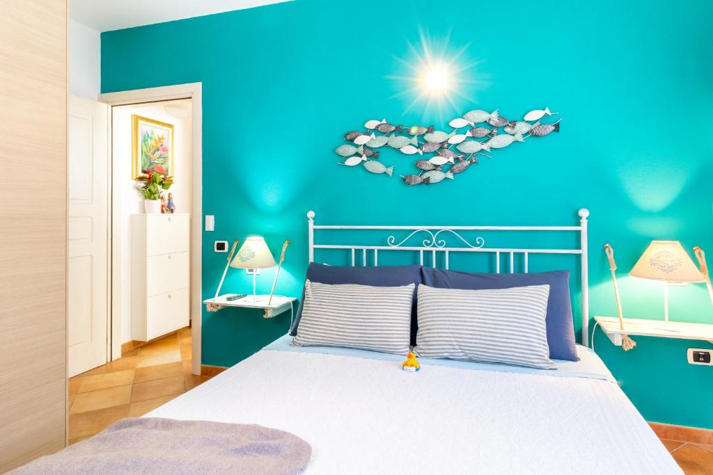 a bedroom with a bed with a blue wall at Residence Dei Fiori in Santa Teresa Gallura