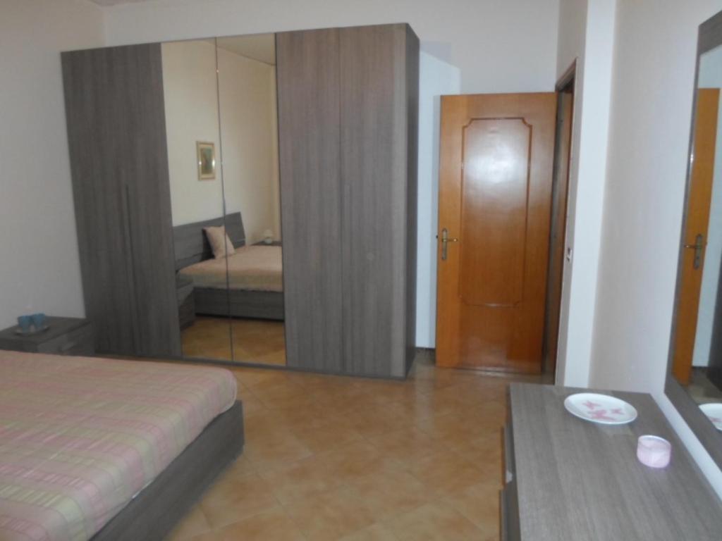 Habitación de hotel con cama y espejo en Casa vacanze " L' ORCHIDEA " Sapri, en Sapri
