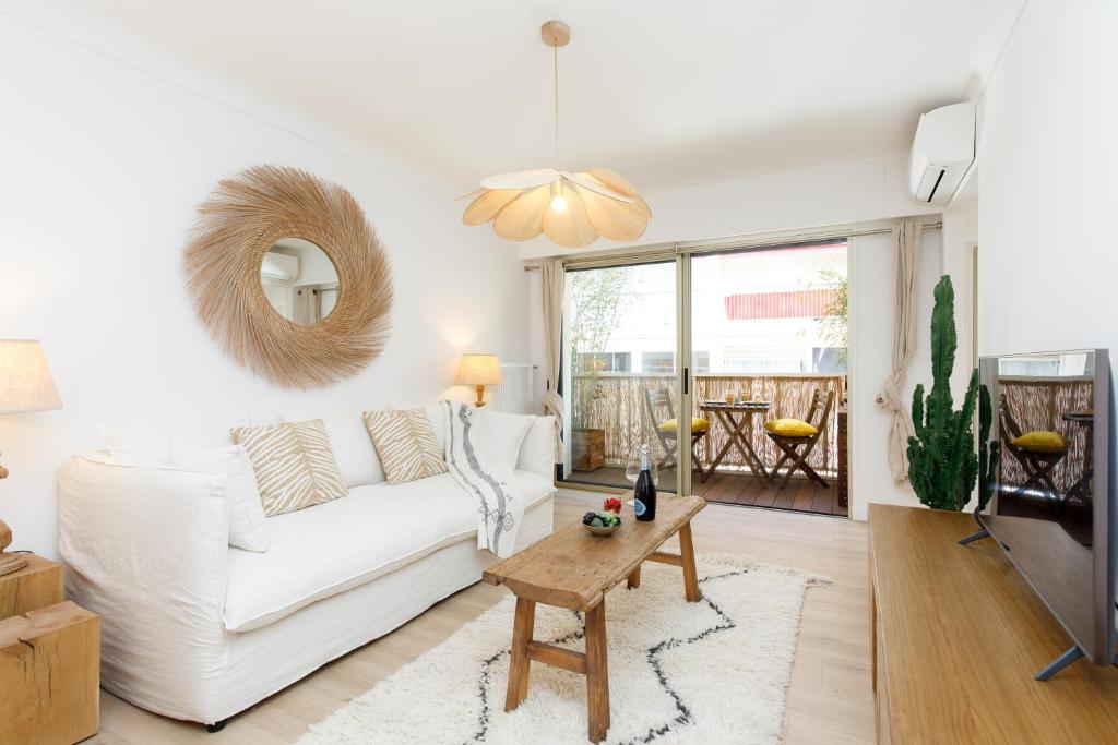 uma sala de estar com um sofá branco e uma mesa em Hippie Palm Beach YourHostHelper em Cannes