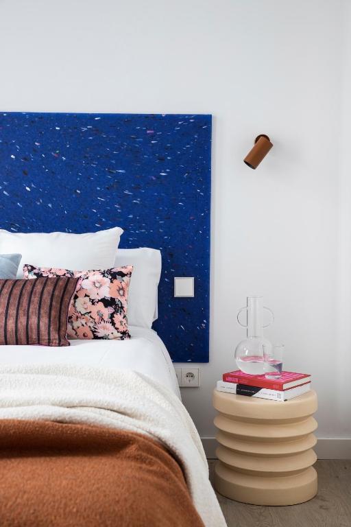 a bedroom with a bed with a night stand next to it at Calatrava - Darya Living in Madrid