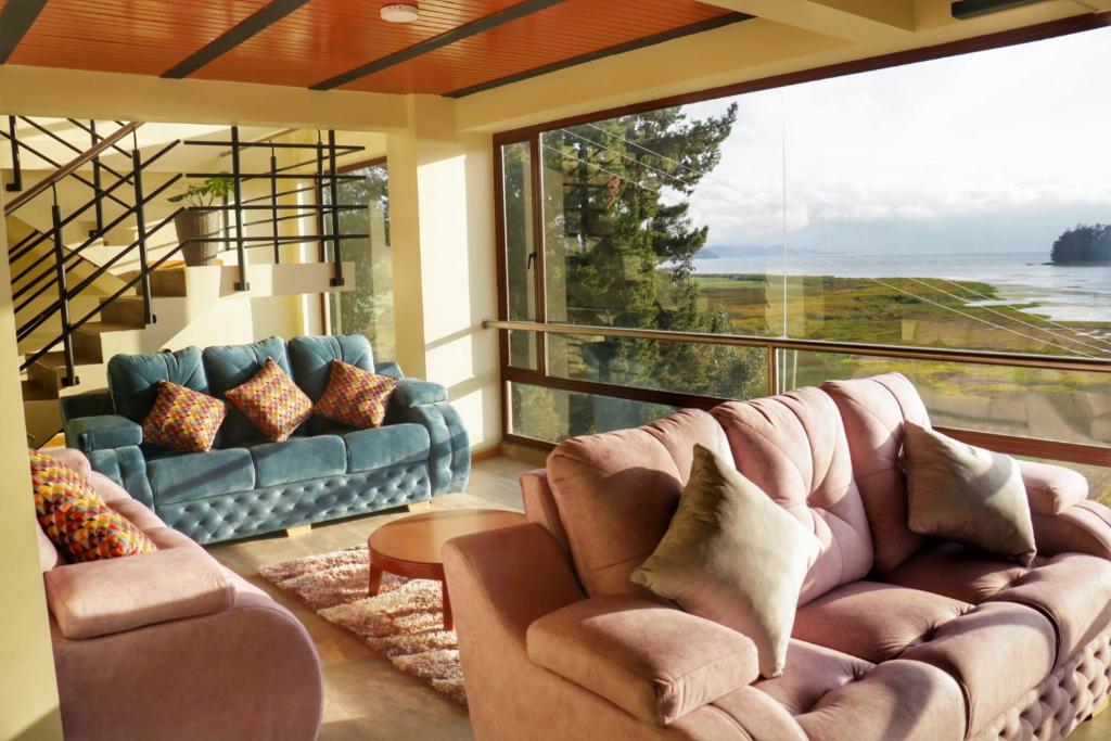 Hotel Rocamonti في أكيتانيا: غرفة معيشة مع أريكة ونافذة كبيرة