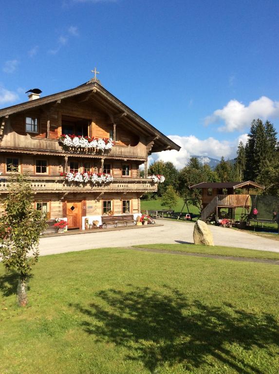 un gran edificio con flores en el balcón en Ferienhof Formegg en Hopfgarten im Brixental