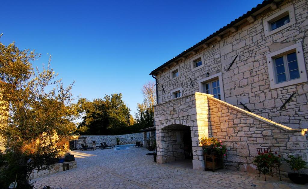 a large stone building with a stone courtyard at Casa della Grofica in Kringa