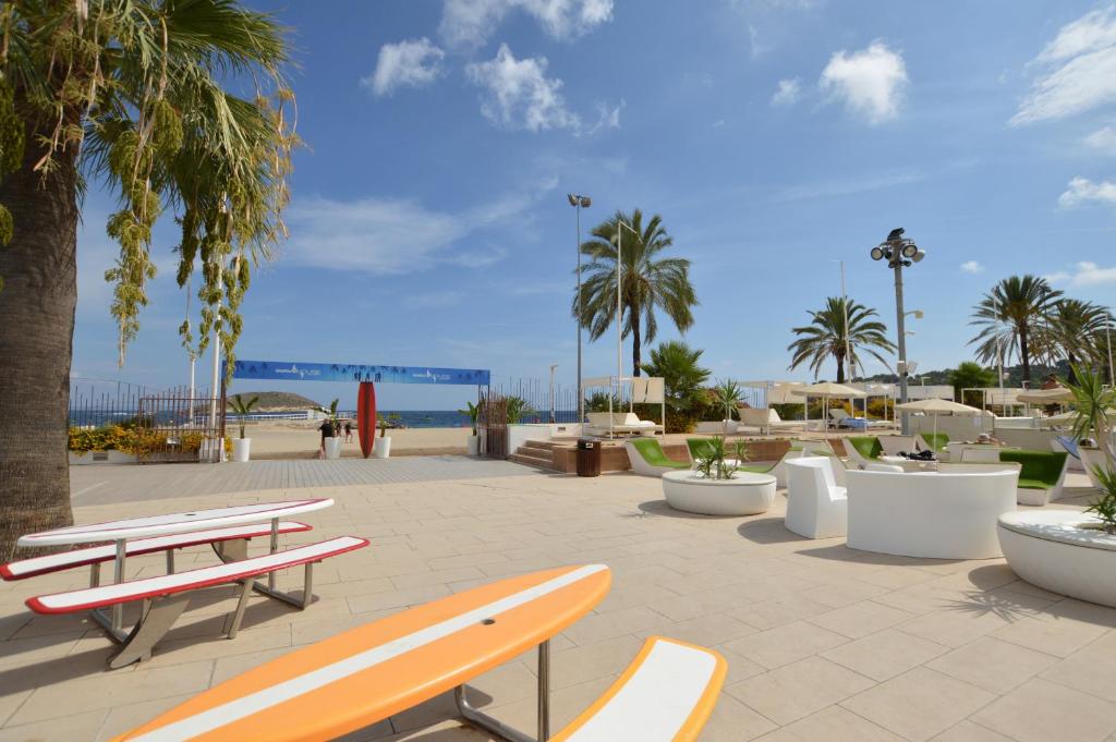 a park with benches and palm trees and the ocean at Seafront Apartment in Magaluf in Magaluf
