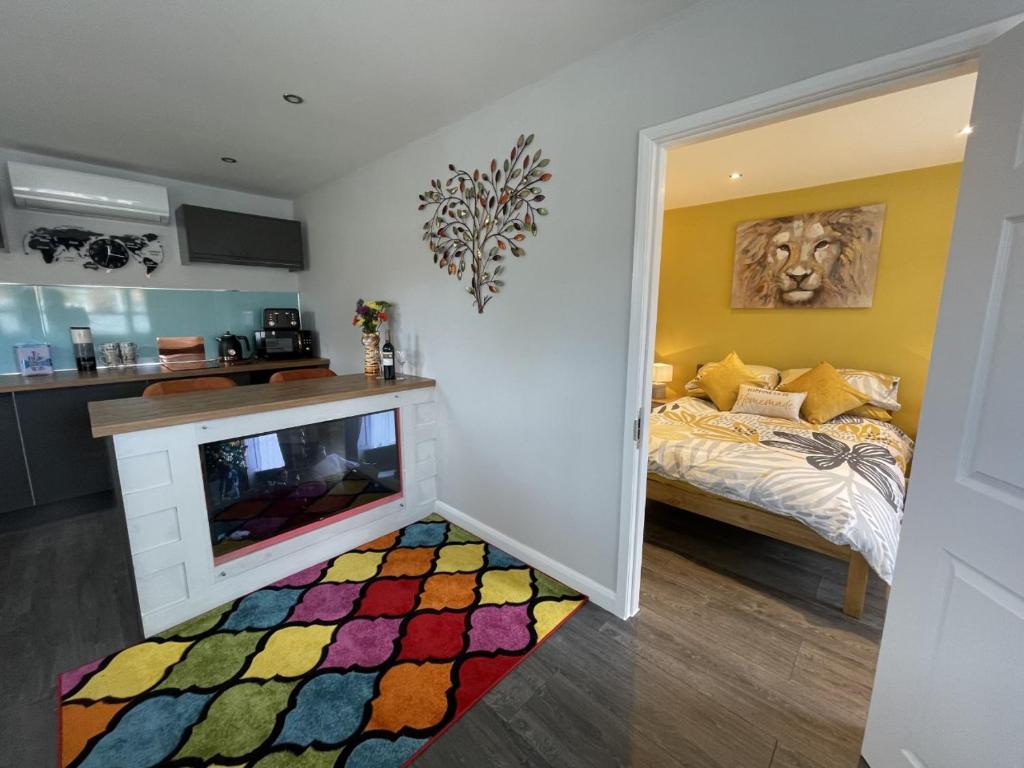 a bedroom with a bed and a fireplace with a colorful rug at Orchard Cottage. in Lincoln