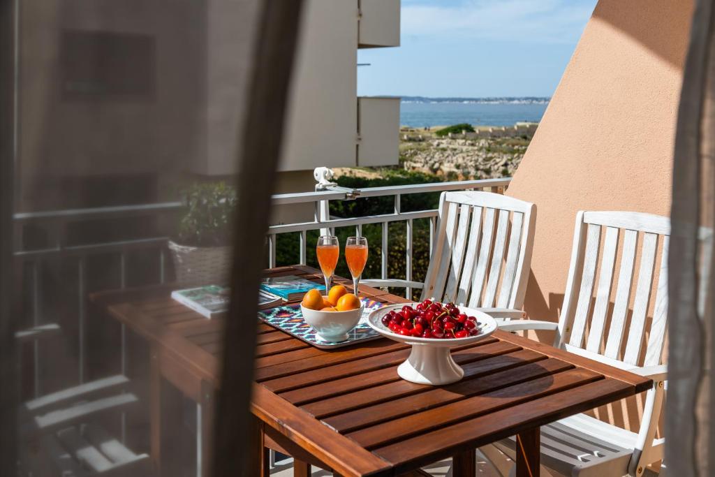 una mesa con un bol de fruta y bebidas en el balcón en Casa di Marco via Fiume, en Gallipoli