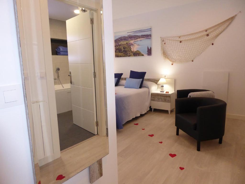 1 dormitorio con cama, silla y espejo en Balcón de la Len, en Quintana de Soba