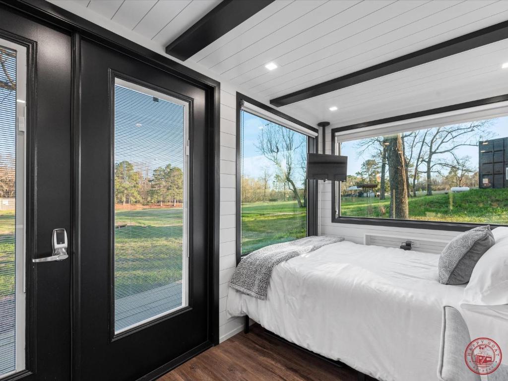1 dormitorio con 1 cama y ventanas grandes en Happy Goat Retreat, en Willis