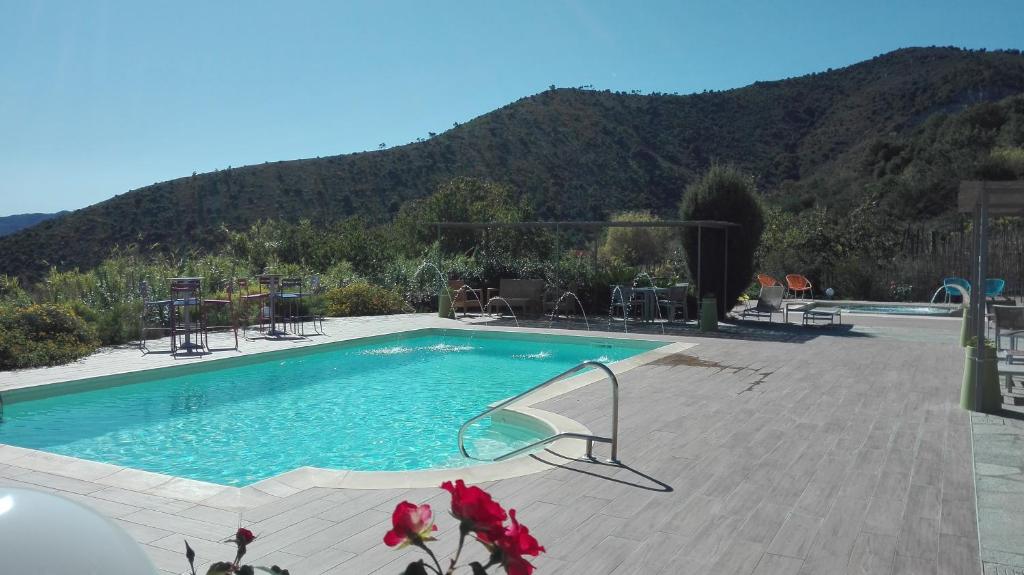 a large swimming pool with a mountain in the background at Oroverde in Bergeggi