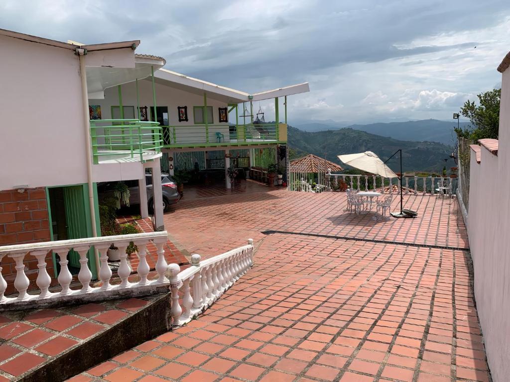 a house with a balcony and a brick patio at Villa NiNa in Manizales