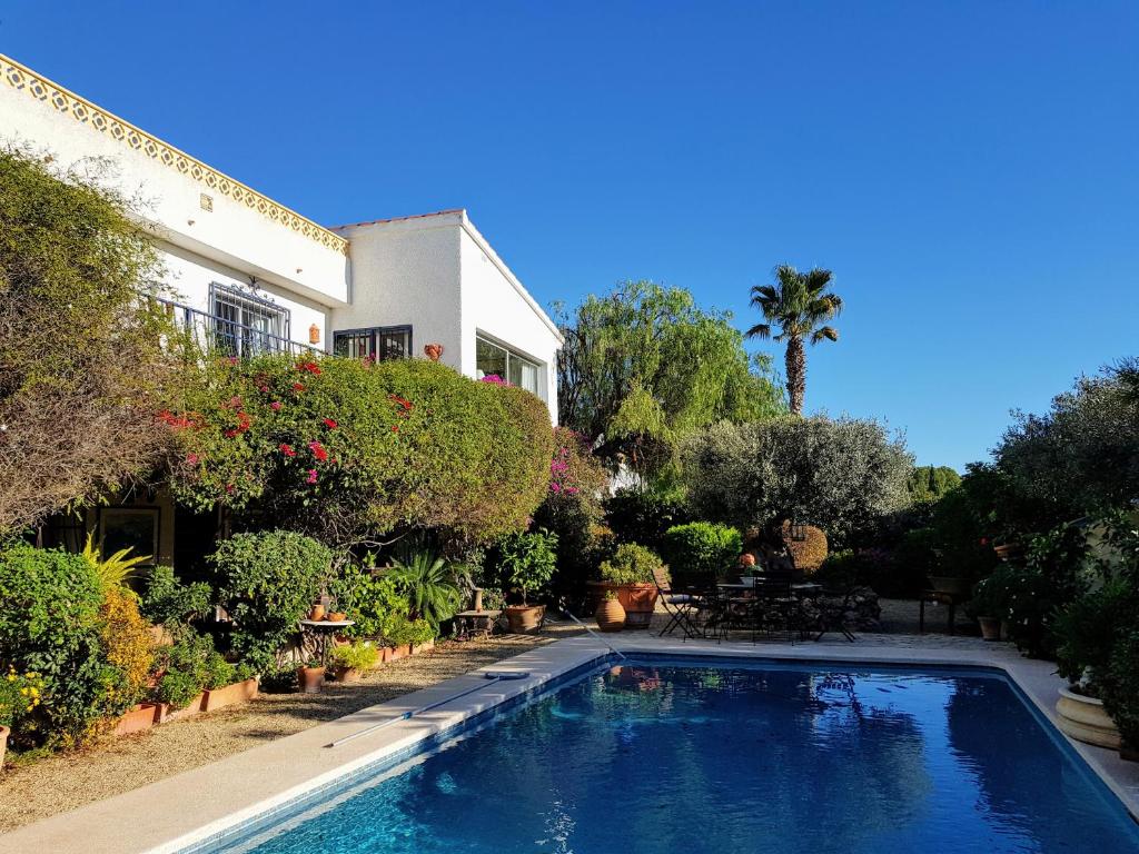 a swimming pool in front of a house at Luxury Villa with Sea and Mountainview in Foyes Blanques