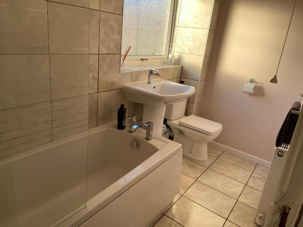 y baño con lavabo, aseo y bañera. en Large spacious 3 bedroom house Westerhope en Lemington