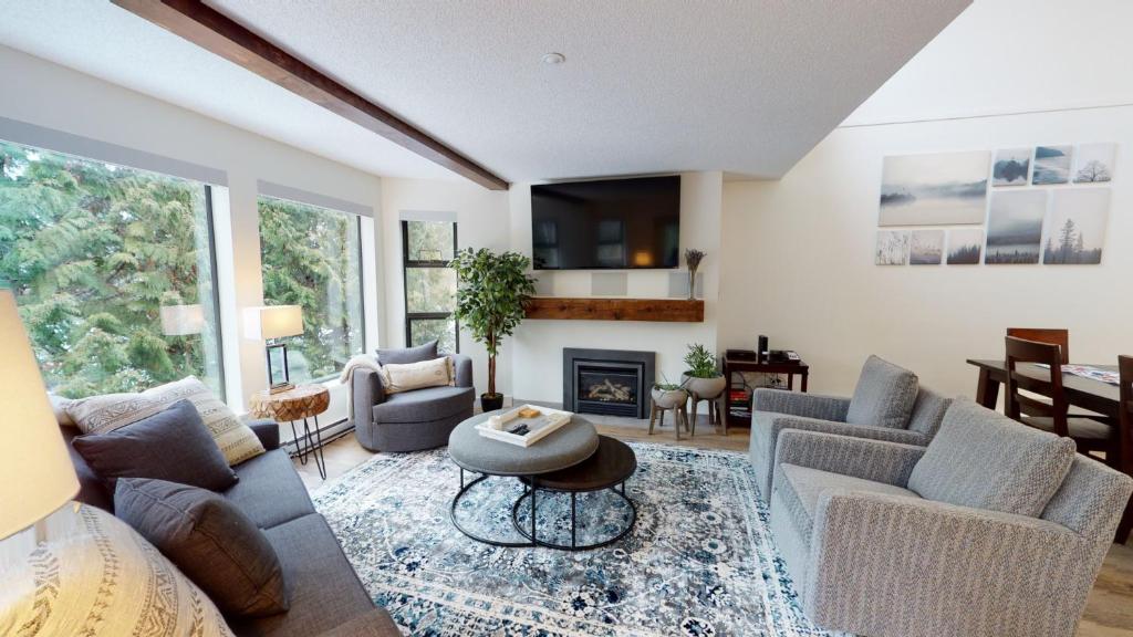 uma sala de estar com sofás e uma lareira em Greyhawk by Whistler Premier em Whistler