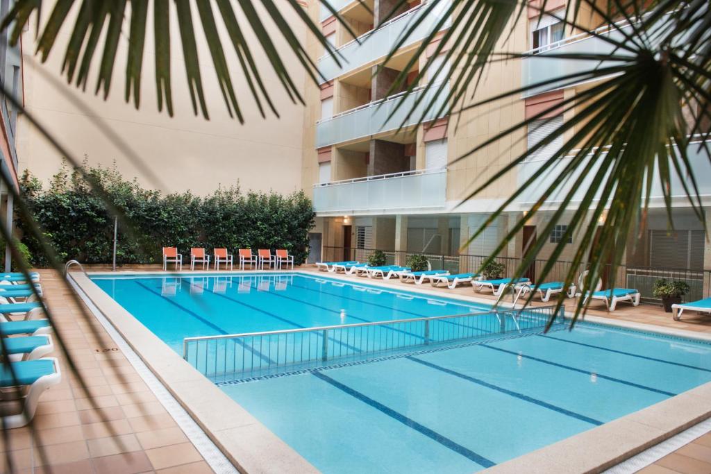 a swimming pool in front of a building at Apartaments Costa d'Or in Calafell