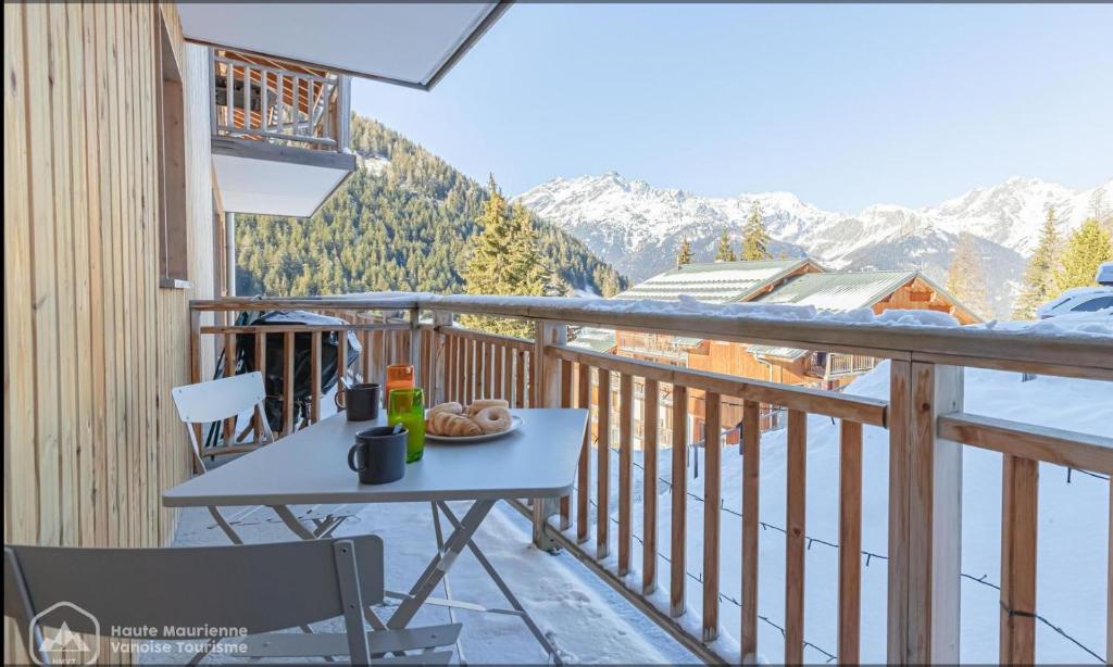 un tavolo su un balcone con vista sulle montagne di Au Centre de la station de ski de Valfréjus - appartement 4-6 personnes a Valfréjus