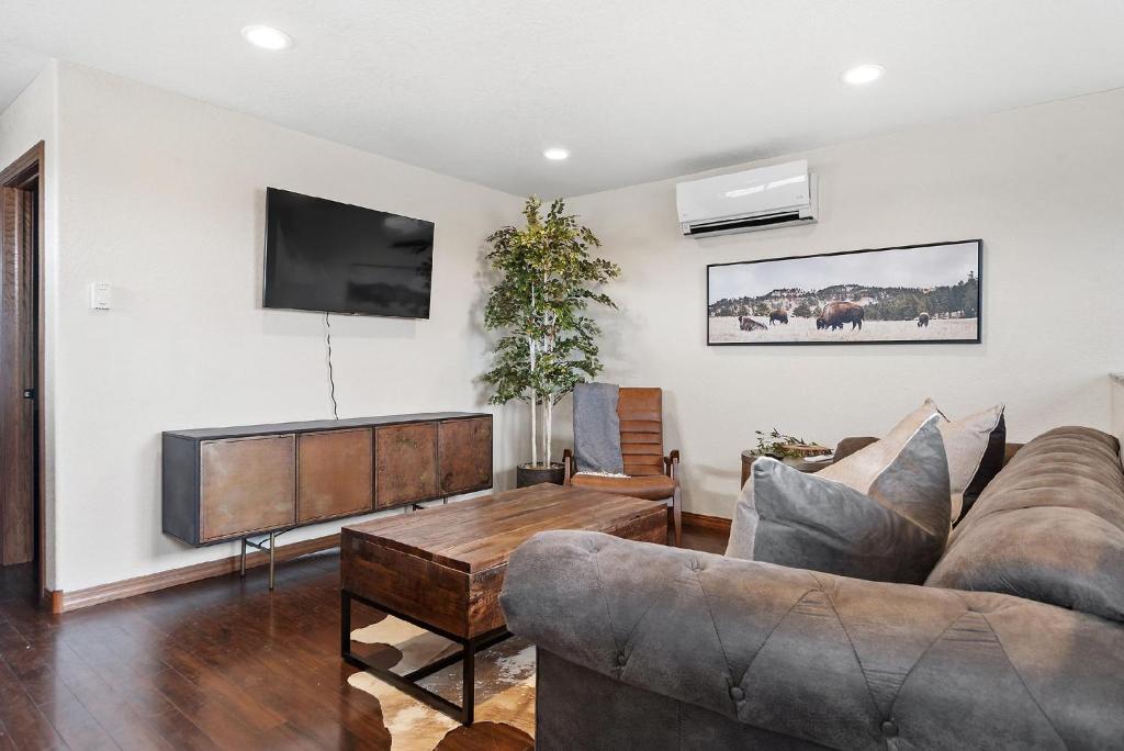 uma sala de estar com um sofá e uma televisão de ecrã plano em The Loft At Raz Hideaway em Sturgis