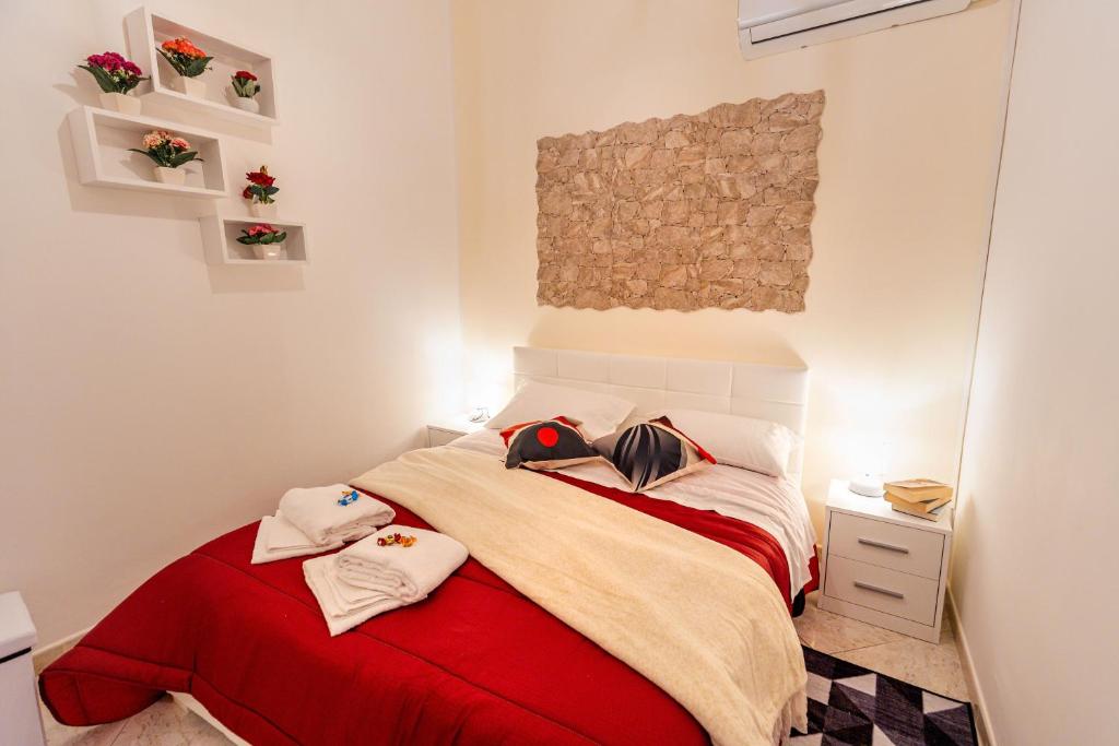 1 dormitorio con 1 cama con manta roja en Residenza Giuseppina, en Siracusa