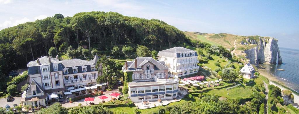 an aerial view of a large building on a hill next to the ocean at Dormy House in Étretat