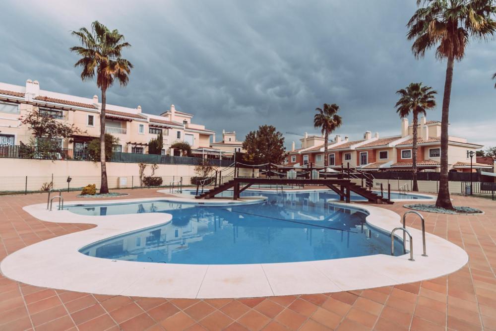 una gran piscina con palmeras y edificios en apartamento Chilches playa en Chilches