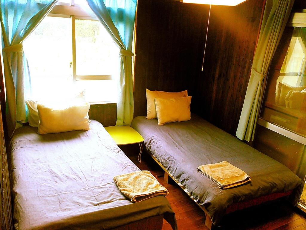 two beds in a small room with a window at Miyakojima - House - Vacation STAY 22179v in Uechi