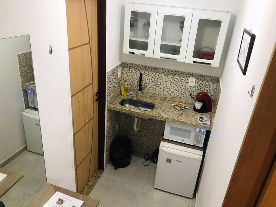 a small kitchen with a sink and a microwave at Vaccani Apart in Macaé