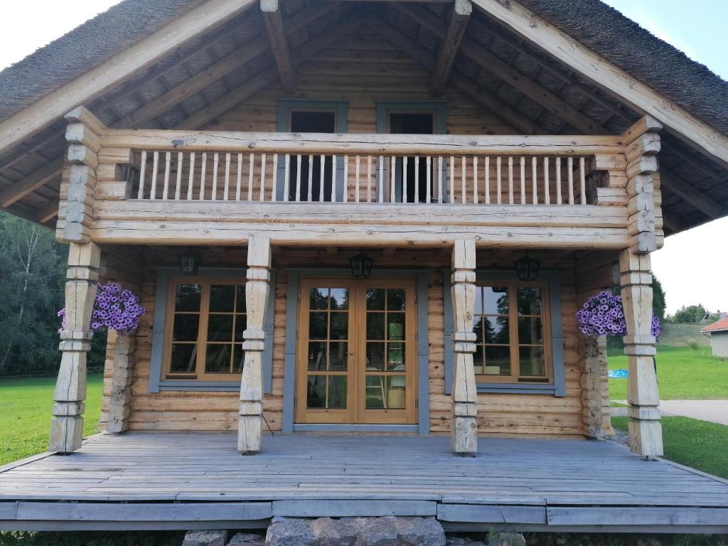 a log cabin with a porch and a deck at Guest House Unguri in Stalbe