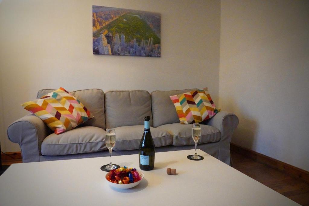 a living room with a couch and a table with wine glasses at Spacious, 4 Bedroom Contractor Home for Large Groups with Private Parking for 3 Large Vehicles, Just 7 Minutes from CMK by Maison 19 in Milton Keynes
