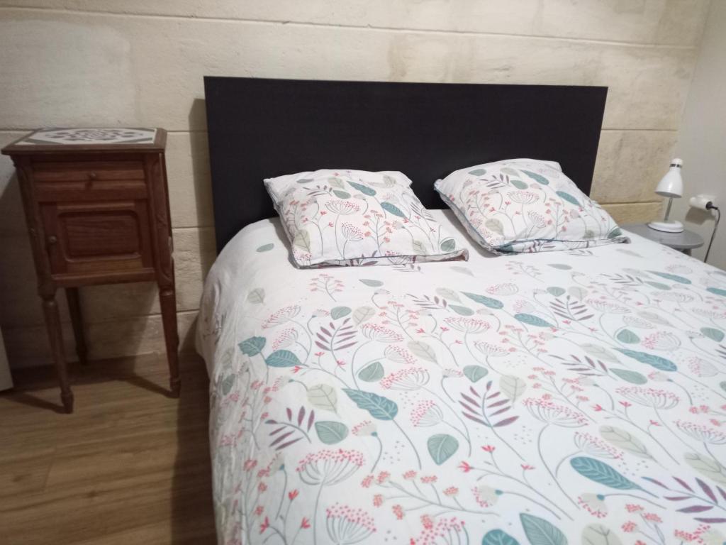 1 cama con 2 almohadas y mesa en Maison entière - 2 chambres doubles en Lormont