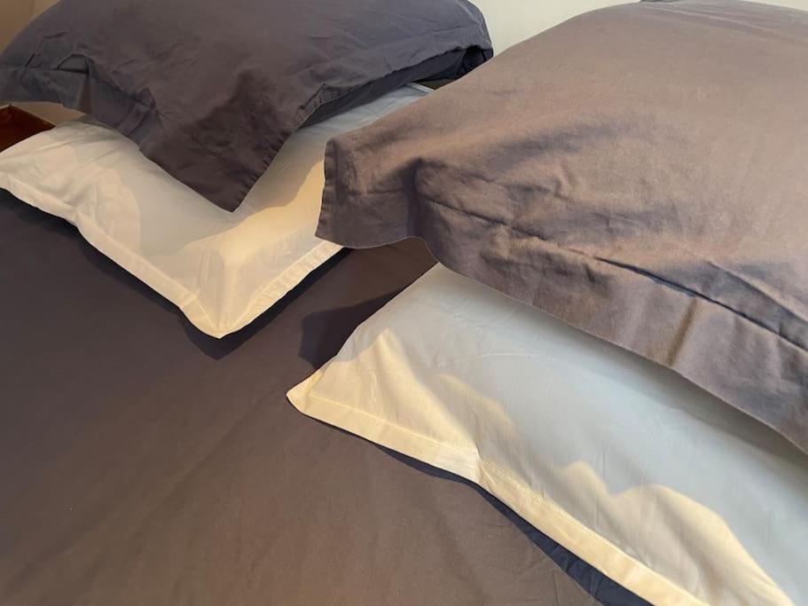 a bed with two pillows on top of each other at Appartement neuf et chaleureux dans Leers centre in Leers