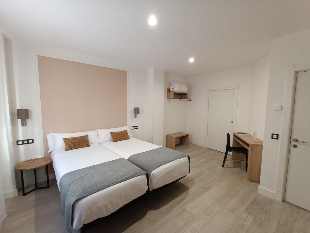 een slaapkamer met een groot bed en een bureau bij Hotel Rural Envero in Pesquera de Duero