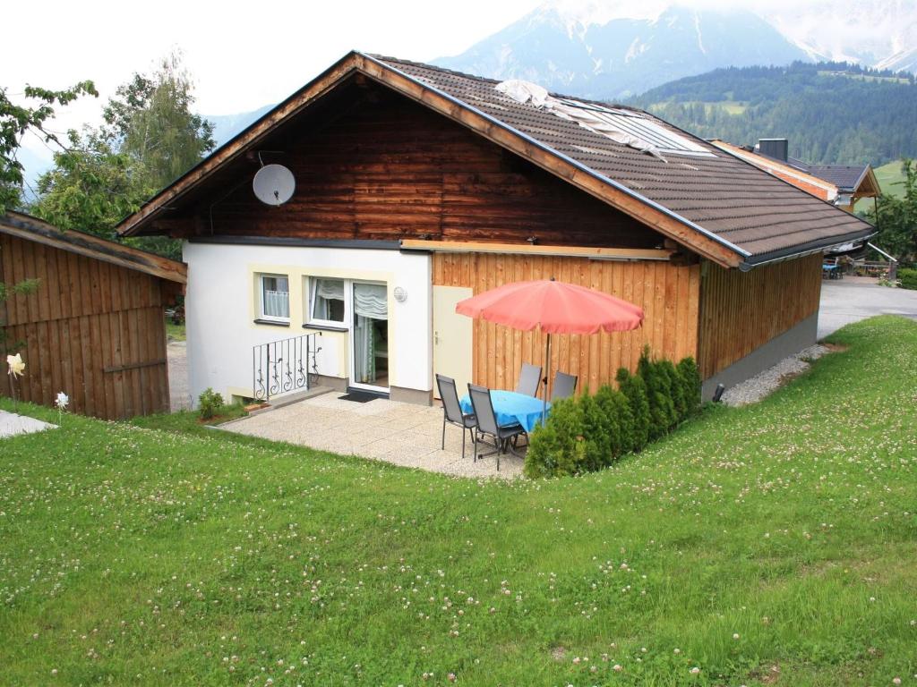 a house with a table and chairs and an umbrella at Lovely Chalet in Maria Alm with Terrace in Maria Alm am Steinernen Meer