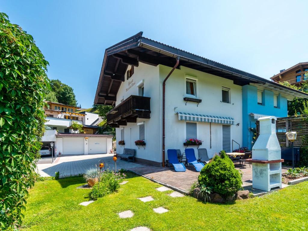 a house with a yard with blue chairs at Apartment in Tirol with private garden in Kirchberg in Tirol