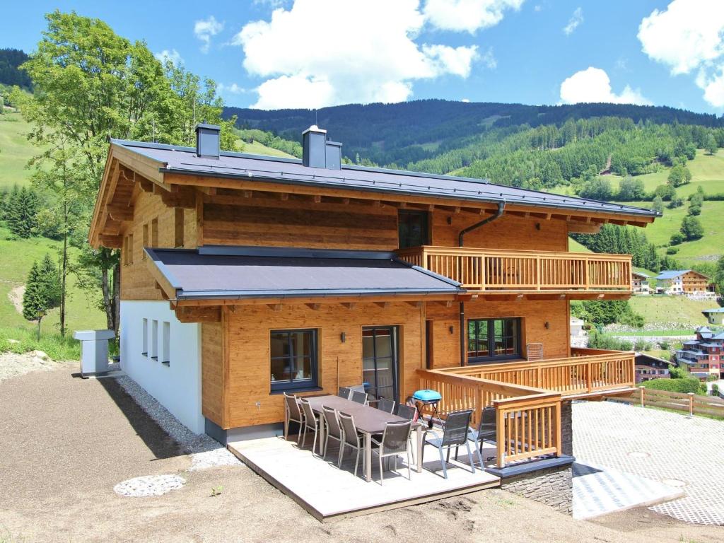a log cabin with a table and chairs on a patio at Luxury Chalet in Saalbach Hinterglemm near Ski Area in Saalbach Hinterglemm