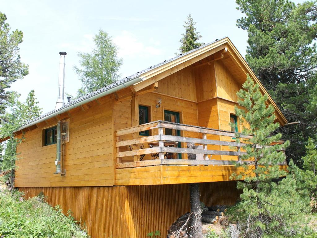 a log cabin with a deck in the woods at Spacious Chalet near Ski Area in Turracherhohe in Turracher Hohe