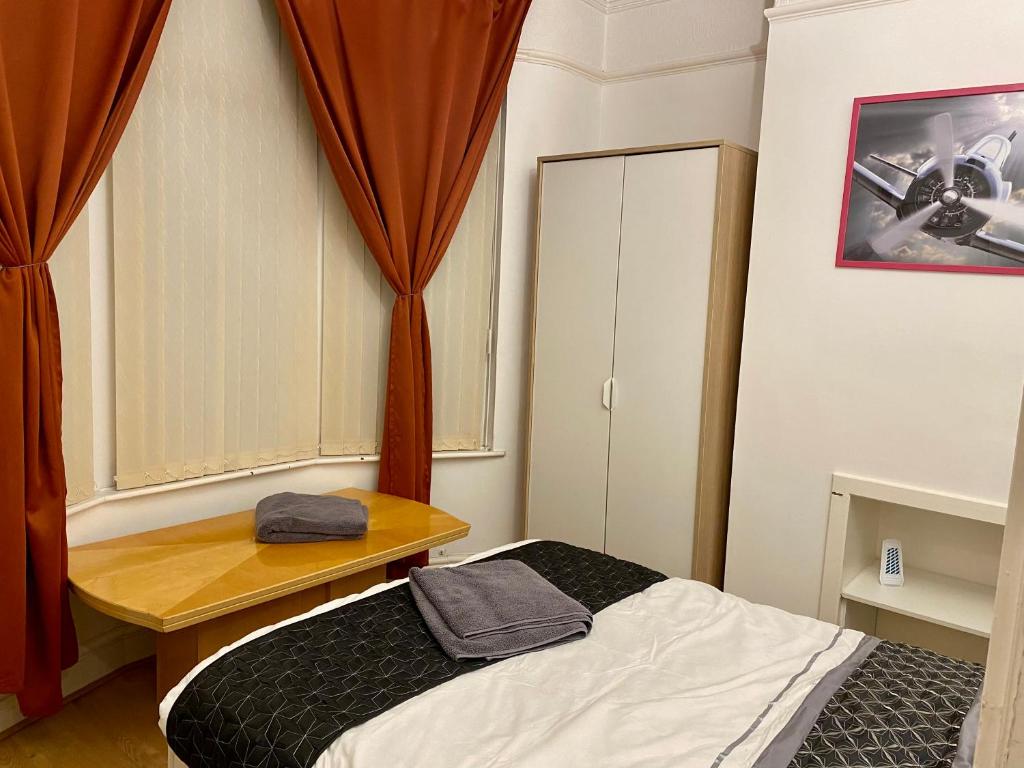 um pequeno quarto com uma cama e uma janela em SureScape House em Liverpool