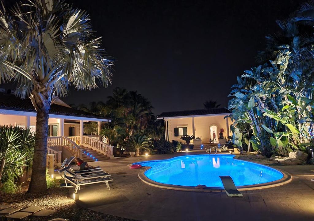 una casa con piscina por la noche en villa Bismarkia, en Siracusa