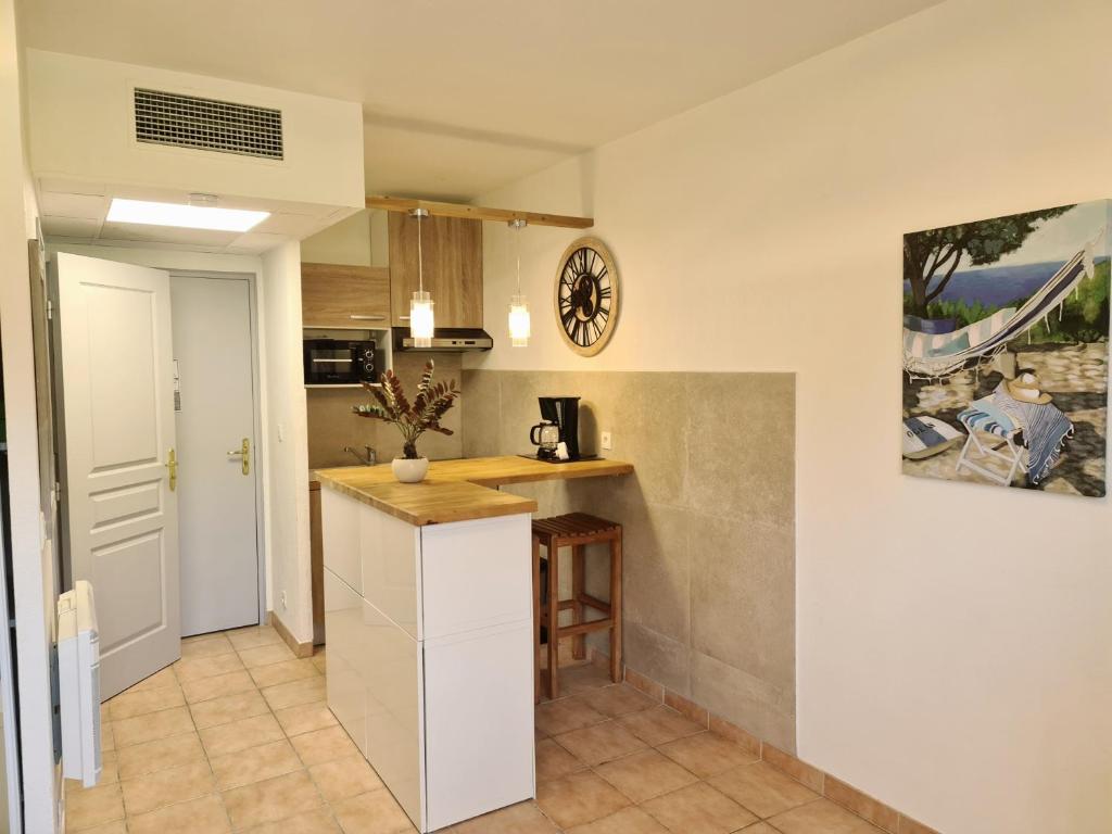 a kitchen with white cabinets and a counter top at Studio meublé face au golf in Mouans-Sartoux