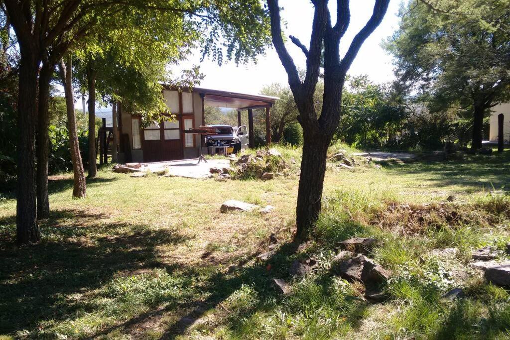a house with a truck parked in a yard at Cabaña en Villa General Belgrano in Villa General Belgrano
