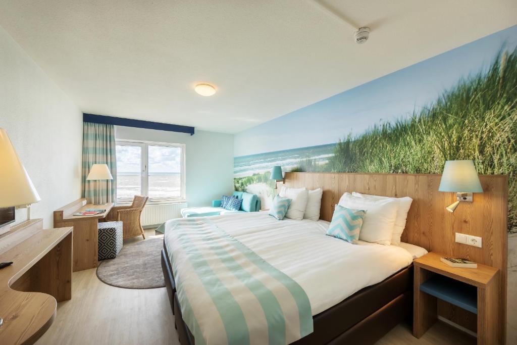 贊德沃特的住宿－贊德沃特帕克斯中心比奇酒店，卧室配有一张大床,墙上挂有绘画作品