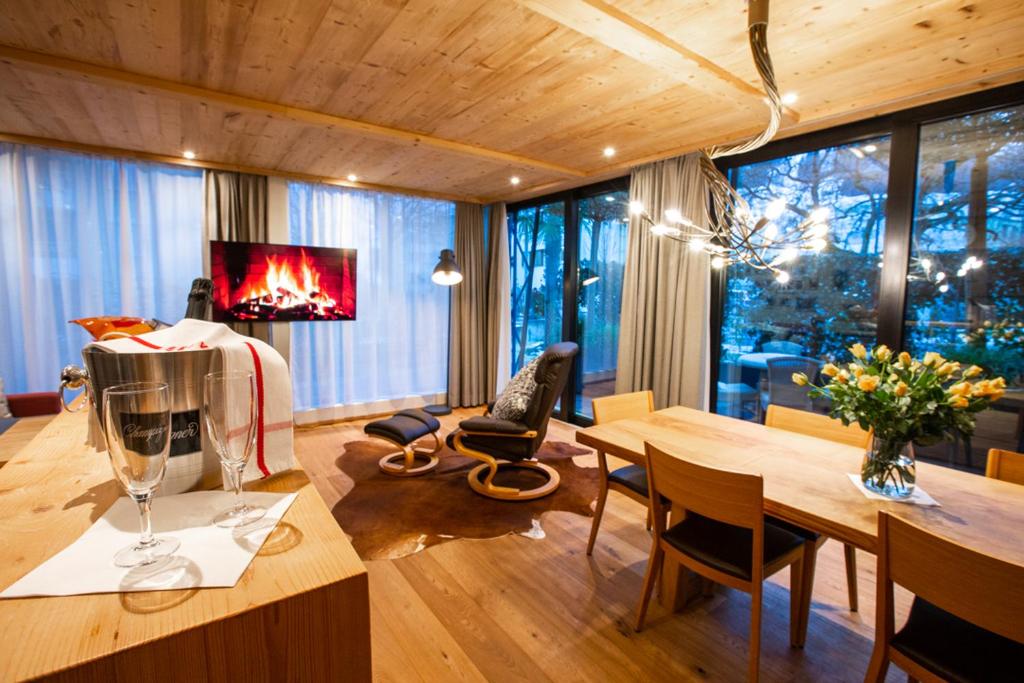 ein Wohnzimmer mit einem Esstisch und einem Kamin in der Unterkunft Apartments Chalet Wirz Travel in Sarnen