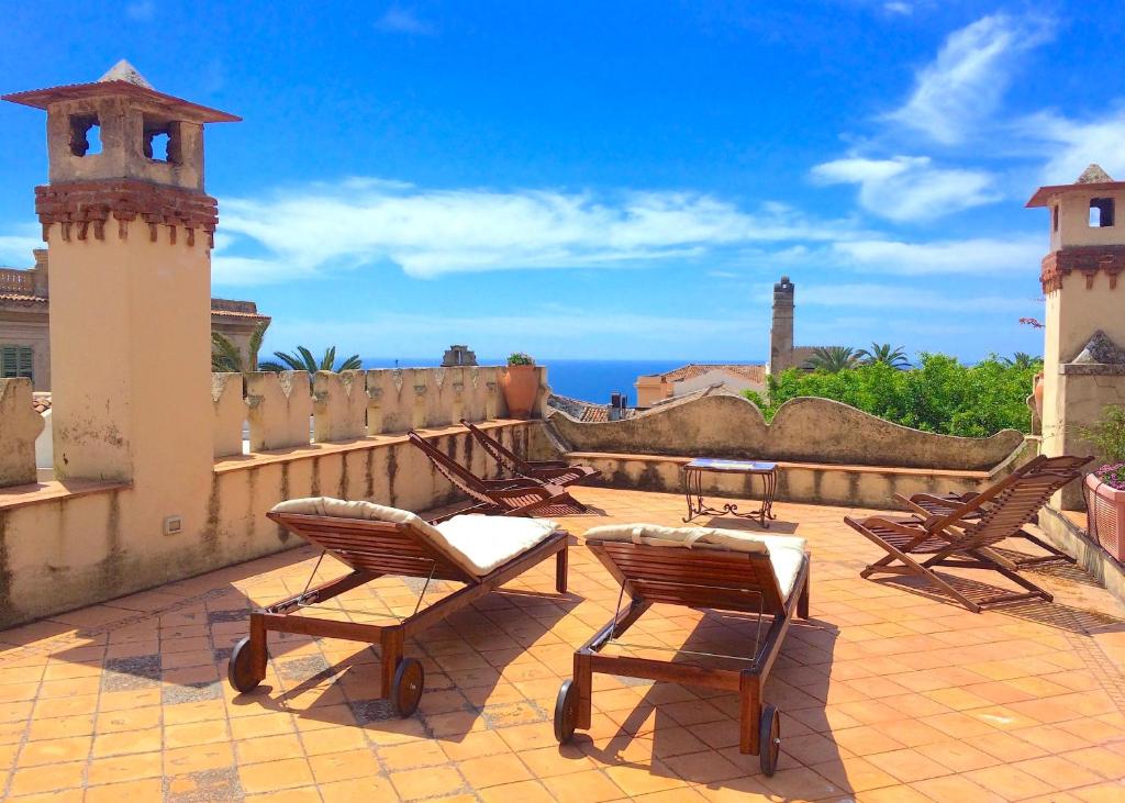 a patio with chairs and a view of the ocean at VILLA MIMOSA Taormina Rooftop Terrace in Taormina