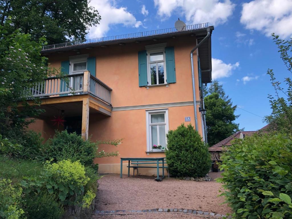 una casa con balcón y un banco frente a ella en Ferienhaus Eisenach en Eisenach