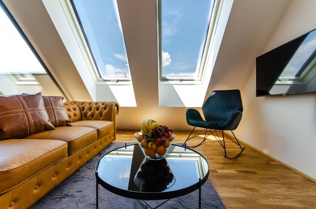 uma sala de estar com um sofá e uma mesa de vidro em Grand Quarters City Residence em Viena