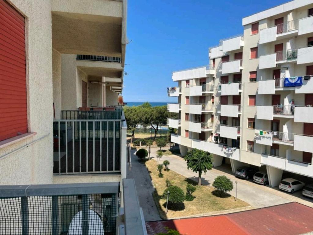 Elle offre une vue sur deux immeubles d'appartements depuis son balcon. dans l'établissement Casa Nina, à Lido di Fermo