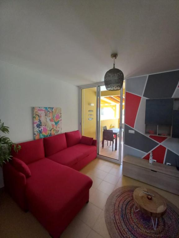a living room with a red couch and a table at Charming Beach Villa Porto Santo in Porto Santo