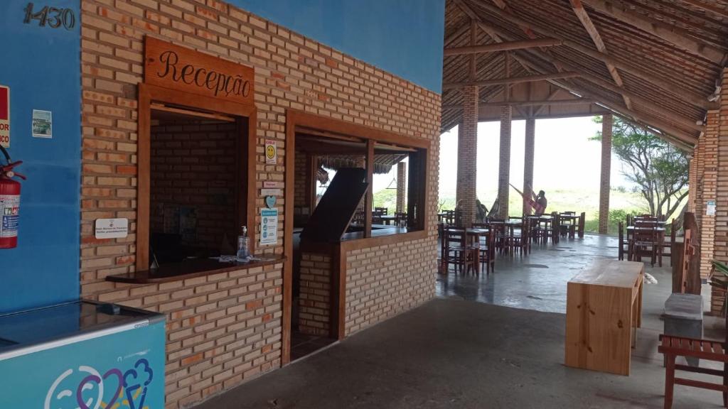 um edifício de tijolos com um restaurante com mesas e cadeiras em Pousada e Restaurante do Francisco em Icapuí